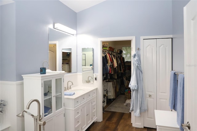 full bath featuring a spacious closet, wood finished floors, and vanity