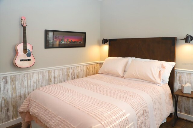 bedroom featuring a wainscoted wall