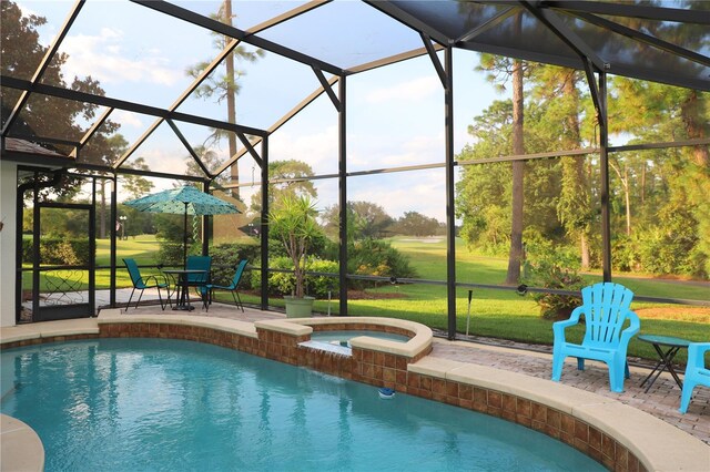 view of pool featuring a patio, glass enclosure, an in ground hot tub, and a yard