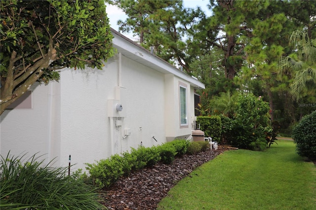 view of home's exterior with a yard and stucco siding