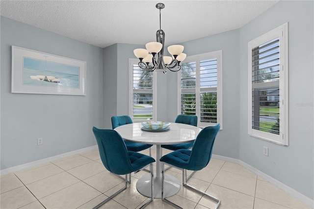 dining room with a textured ceiling, a chandelier, and light tile patterned floors