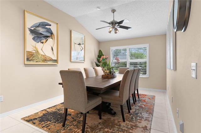 tiled dining room featuring a textured ceiling, ceiling fan, and lofted ceiling