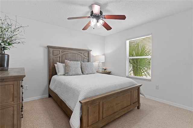 bedroom with ceiling fan, light carpet, and a textured ceiling