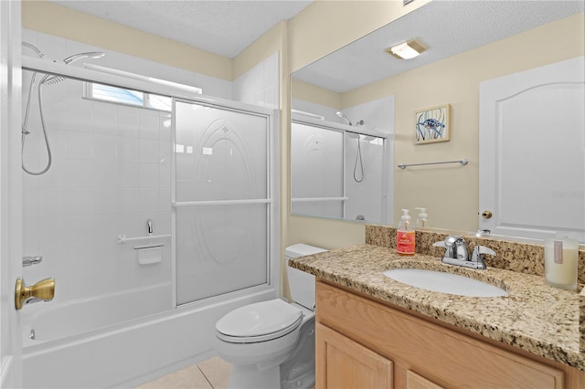3401 Fairfield St, The Villages, FL 32162 - bathroom with vanity, toilet, a textured ceiling, tile patterned floors, and combined bath / shower with glass door