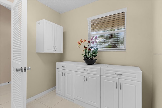 clothes washing area featuring light tile patterned floors