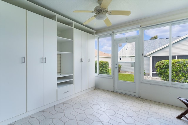 unfurnished sunroom featuring ceiling fan