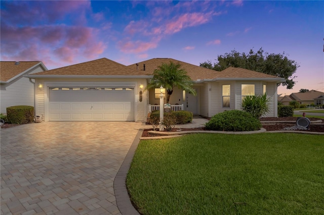 view of front facade with a yard and a garage