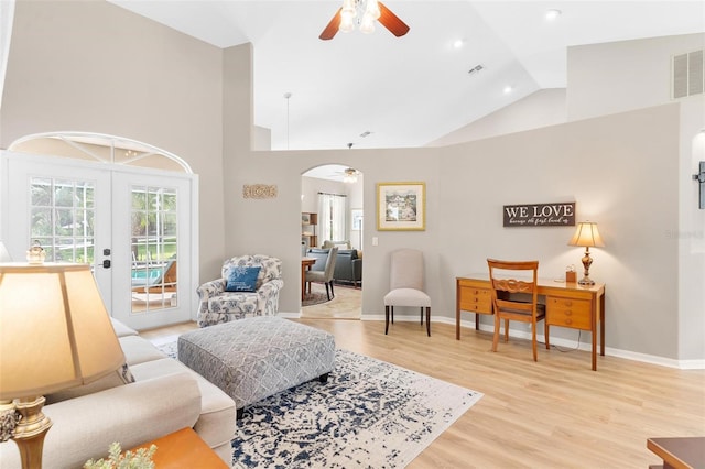 living area featuring light wood-type flooring, ceiling fan, high vaulted ceiling, and french doors