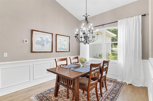 dining area featuring light wood-type flooring, high vaulted ceiling, plenty of natural light, and an inviting chandelier