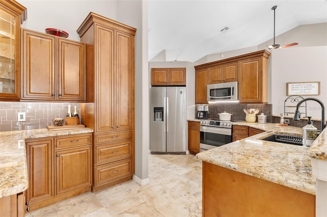 kitchen with stainless steel appliances, sink, light stone countertops, decorative backsplash, and vaulted ceiling