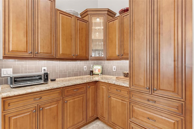 kitchen featuring tasteful backsplash and light stone countertops