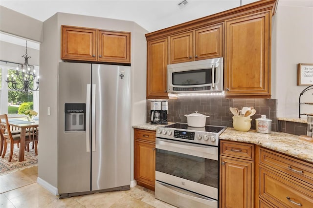 kitchen featuring a notable chandelier, light hardwood / wood-style flooring, backsplash, stainless steel appliances, and light stone counters