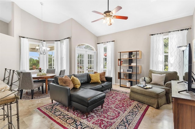 living room featuring ceiling fan with notable chandelier and high vaulted ceiling