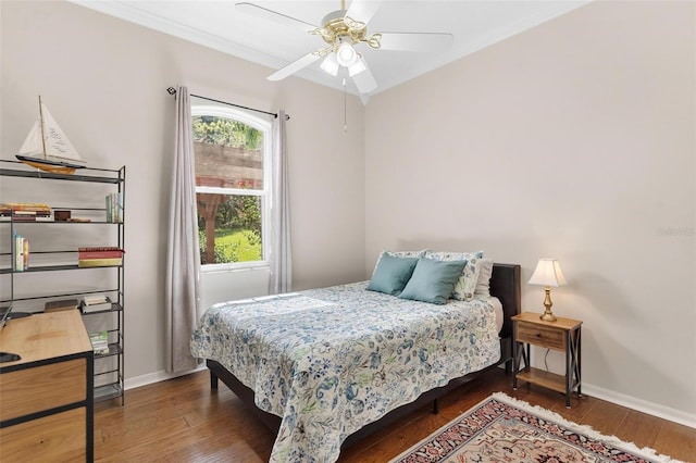 bedroom with ceiling fan, dark hardwood / wood-style floors, and ornamental molding