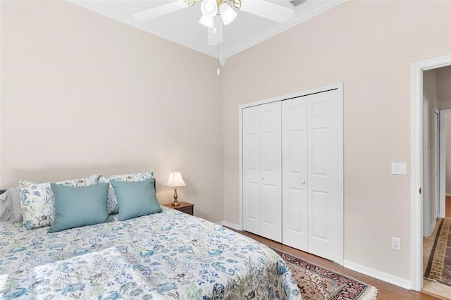 bedroom featuring crown molding, ceiling fan, a closet, and wood-type flooring