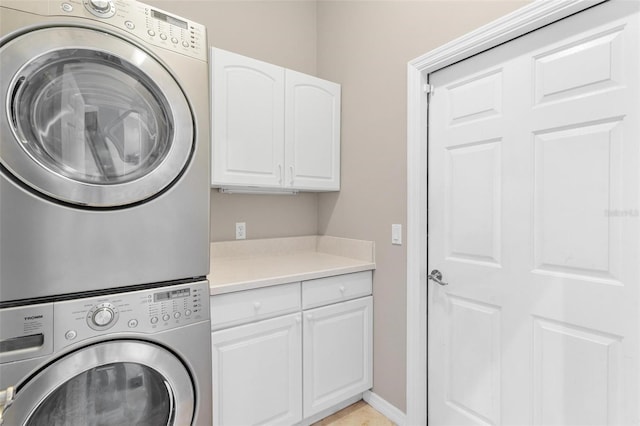 washroom featuring cabinets and stacked washer and dryer