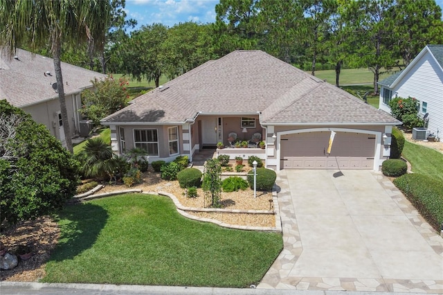 view of front of house with cooling unit, a garage, and a front yard