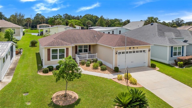 ranch-style house with a garage, concrete driveway, a residential view, covered porch, and a front lawn