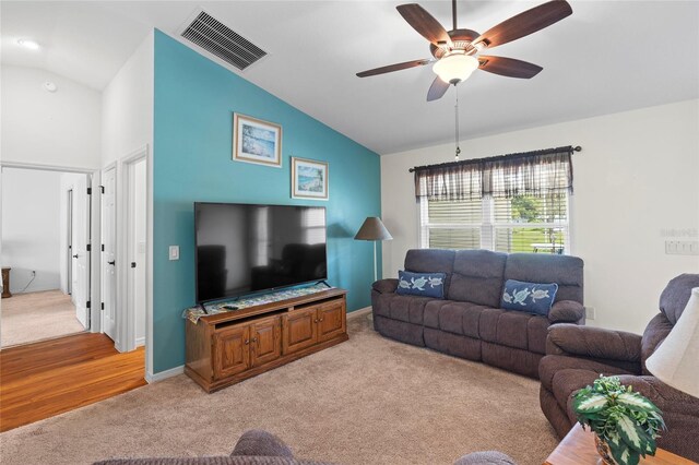 living room with ceiling fan, lofted ceiling, and light colored carpet