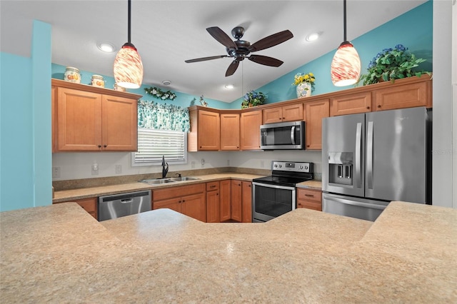 kitchen featuring appliances with stainless steel finishes, light countertops, a sink, and hanging light fixtures