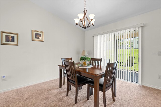 dining space featuring light colored carpet and a chandelier