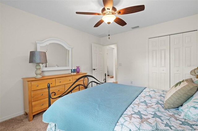 bedroom with ceiling fan, carpet flooring, visible vents, baseboards, and a closet