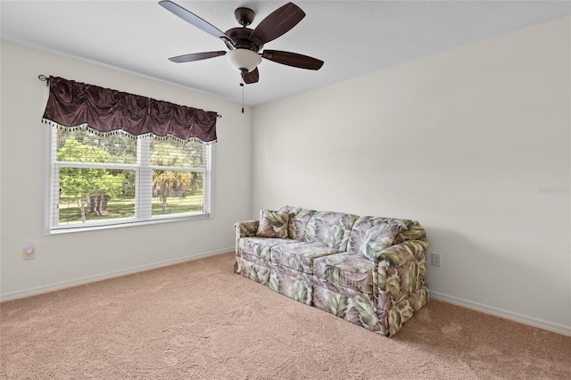 living area featuring a ceiling fan, carpet, and baseboards