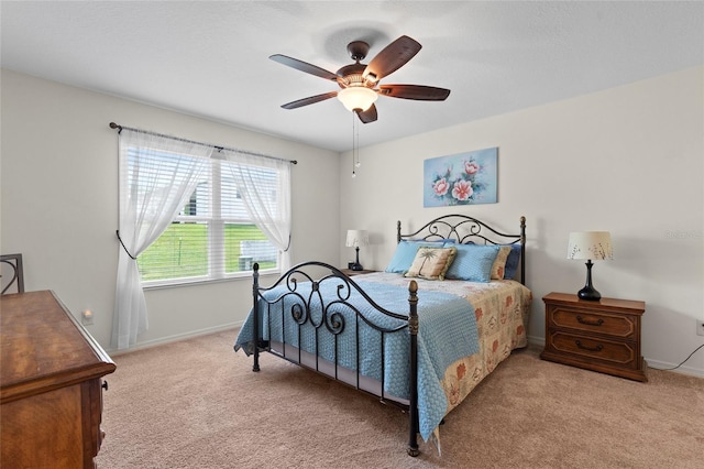 bedroom with light carpet, ceiling fan, and baseboards