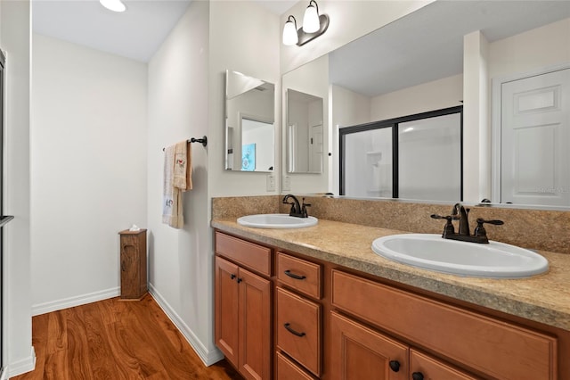 bathroom featuring a shower with shower door, hardwood / wood-style flooring, and vanity