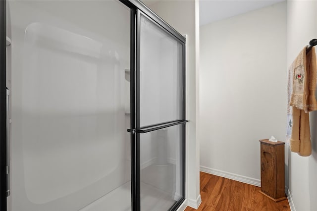 bathroom featuring a shower with shower door and hardwood / wood-style flooring