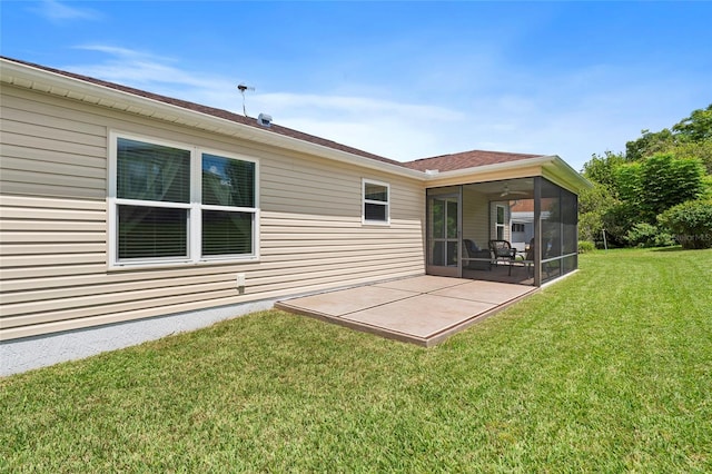 rear view of property featuring ceiling fan, a yard, and a patio