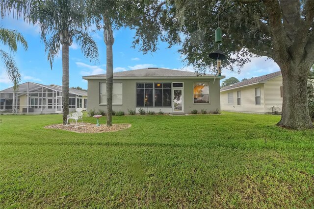 32915 Crooked Oaks Ln, Leesburg, FL 34748 - rear view of property featuring a lawn and stucco siding