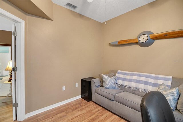 32915 Crooked Oaks Ln, Leesburg, FL 34748 - living area featuring light wood-style floors, visible vents, a textured ceiling, and baseboards