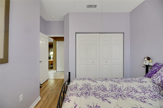 32915 Crooked Oaks Ln, Leesburg, FL 34748 - bedroom featuring light wood-style flooring, a textured ceiling, visible vents, and a closet