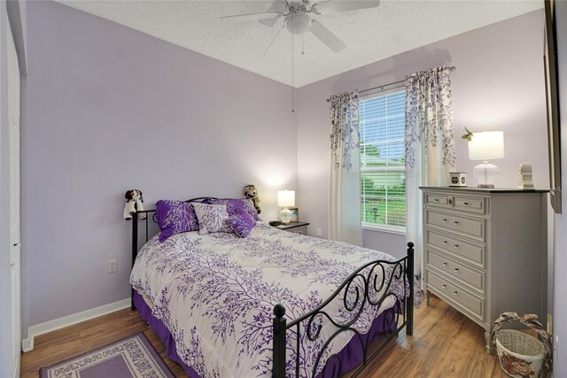 32915 Crooked Oaks Ln, Leesburg, FL 34748 - bedroom featuring a ceiling fan, a textured ceiling, baseboards, and wood finished floors