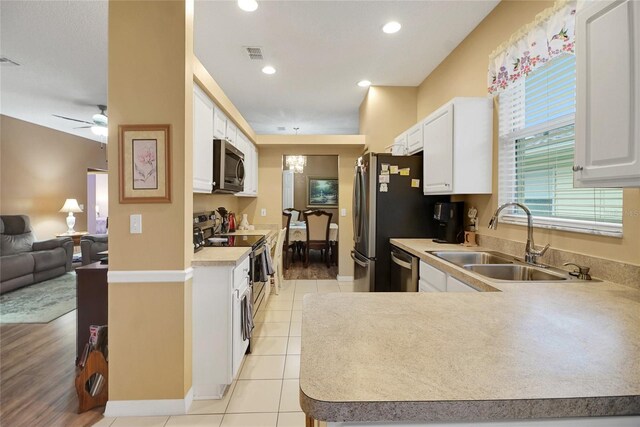 32915 Crooked Oaks Ln, Leesburg, FL 34748 - kitchen with open floor plan, appliances with stainless steel finishes, a sink, and white cabinetry
