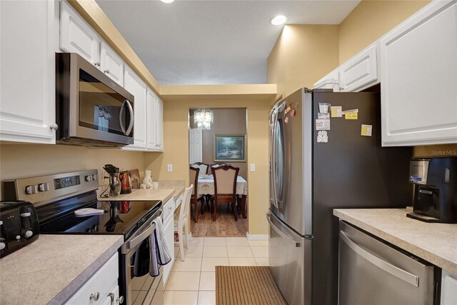 32915 Crooked Oaks Ln, Leesburg, FL 34748 - kitchen featuring white cabinets, light tile patterned floors, stainless steel appliances, and light countertops
