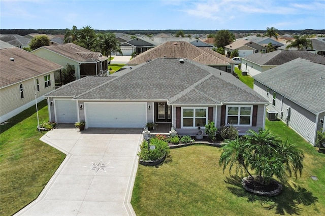 view of front facade featuring concrete driveway, a front lawn, an attached garage, and a residential view