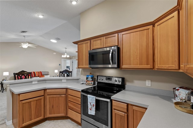 kitchen with stainless steel appliances, a peninsula, light countertops, and visible vents