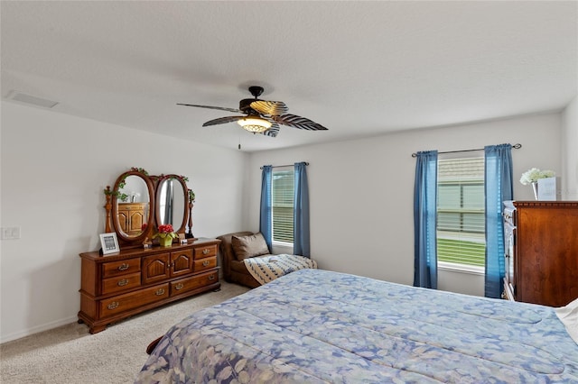 bedroom featuring light colored carpet, multiple windows, and a textured ceiling