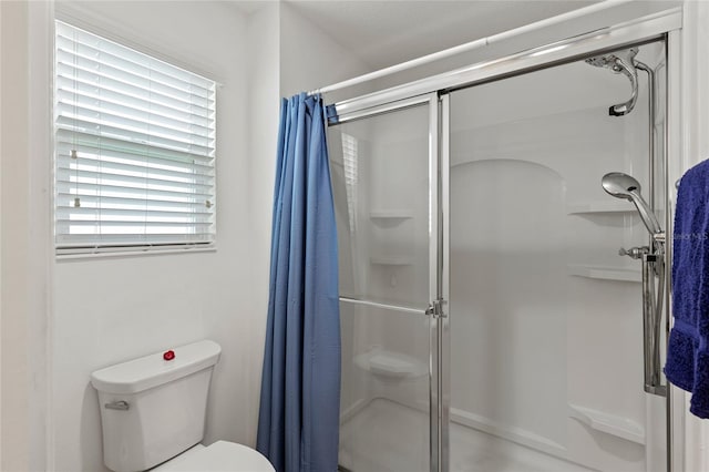 bathroom with toilet and a shower stall