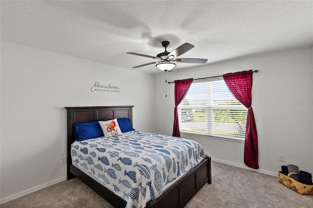 bedroom featuring baseboards, a textured ceiling, a ceiling fan, and light colored carpet