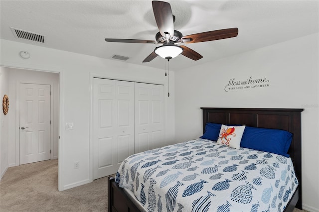 bedroom with ceiling fan, a closet, visible vents, and light colored carpet