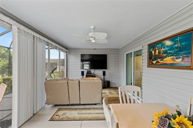 living room with a textured ceiling and a ceiling fan