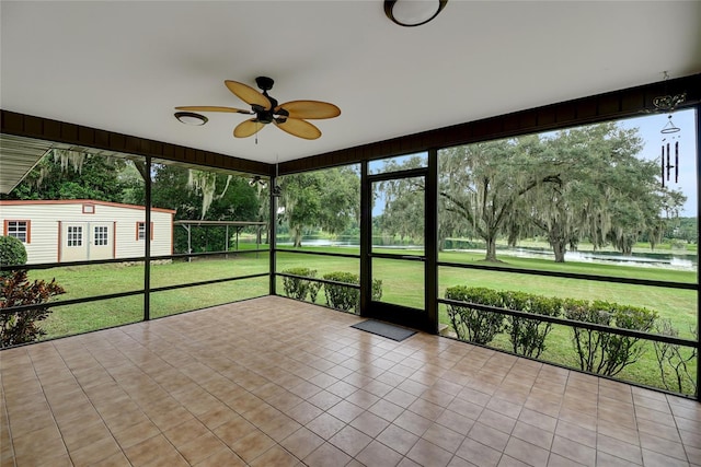 unfurnished sunroom featuring ceiling fan