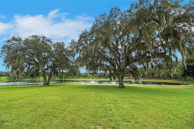 surrounding community with a lawn and a water view