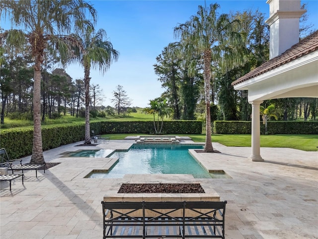 view of swimming pool featuring an in ground hot tub, a patio, and a lawn