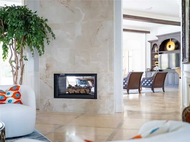 living room featuring beam ceiling, a multi sided fireplace, and ornamental molding