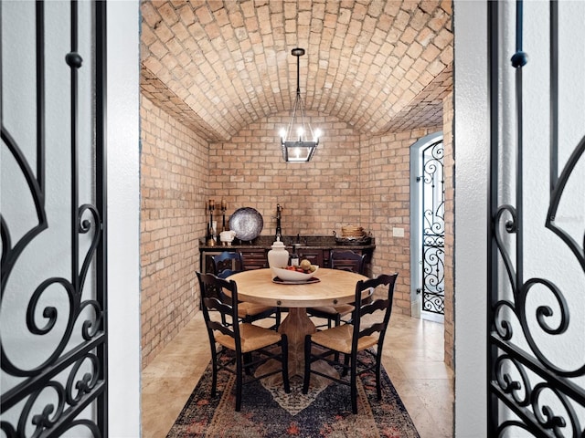 wine area with brick ceiling, brick wall, lofted ceiling, and a notable chandelier