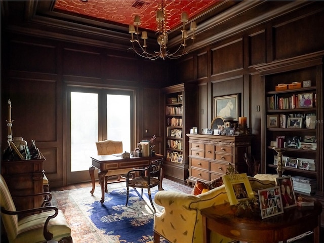 home office with built in features, crown molding, and a chandelier